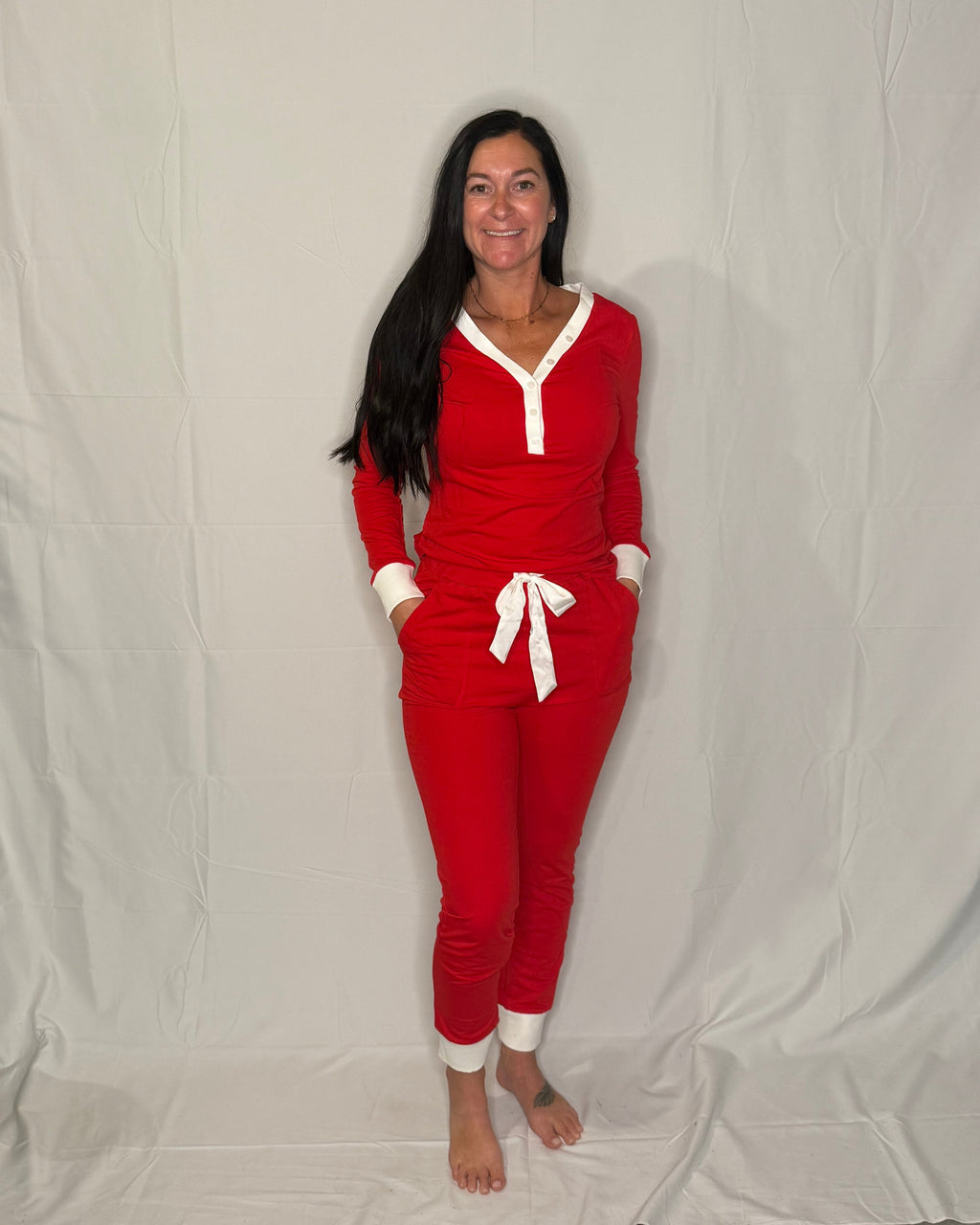 Woman wearing a red outfit with white accents against a plain background