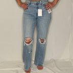 Ripped jeans with tags on a white background