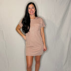 Woman wearing a beige dress against a plain background