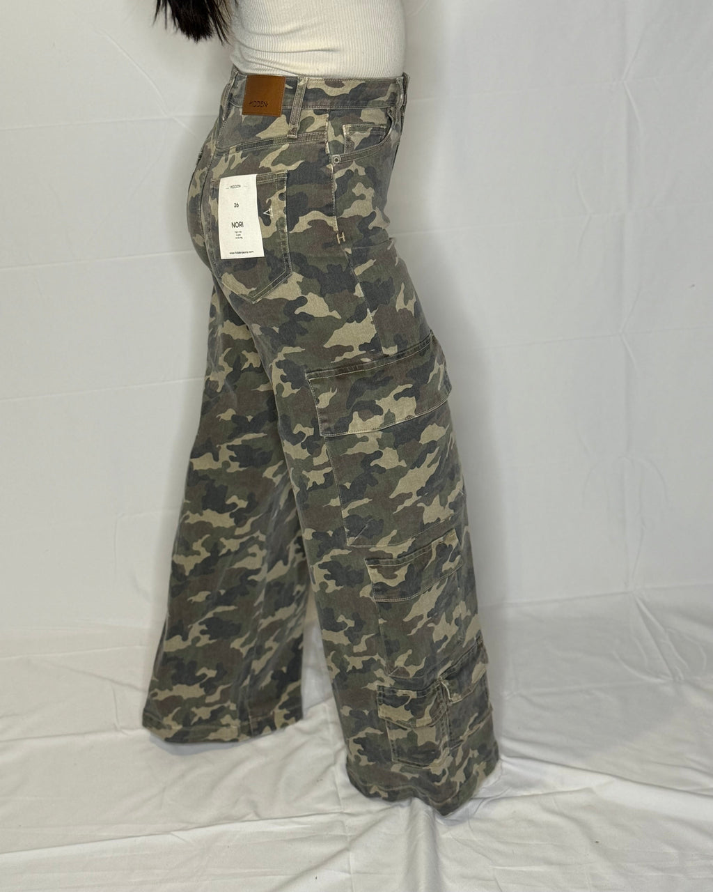 Camouflage pants with a tag on a white background