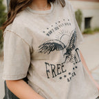 Person wearing a beige t-shirt with an eagle graphic and 'Free' text.