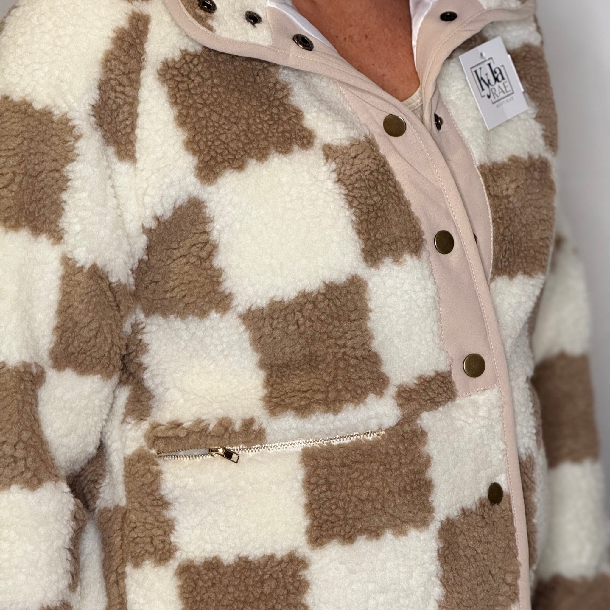 Plaid patterned jacket with a checkered design in brown and white.