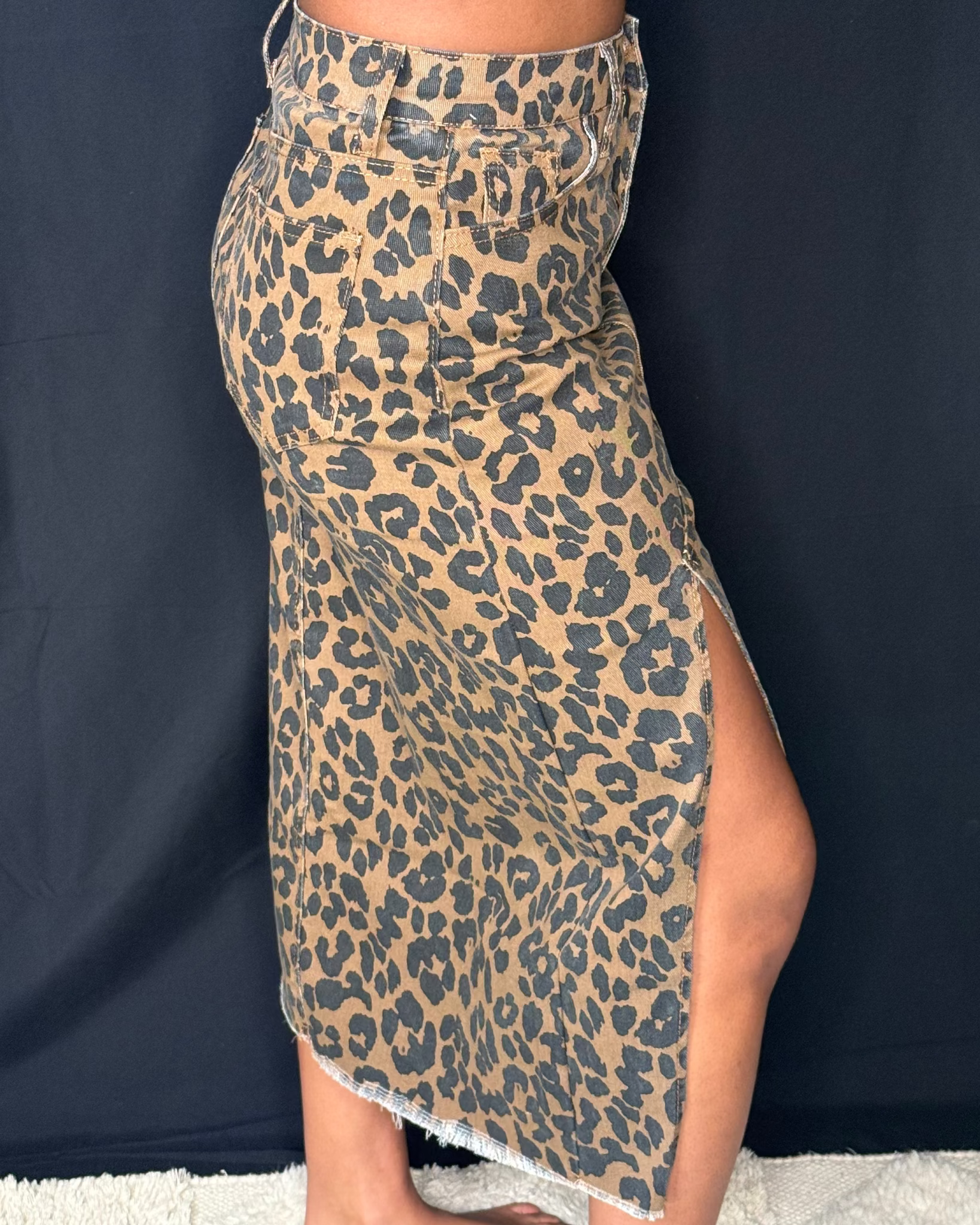 Leopard print skirt worn by a person against a dark background