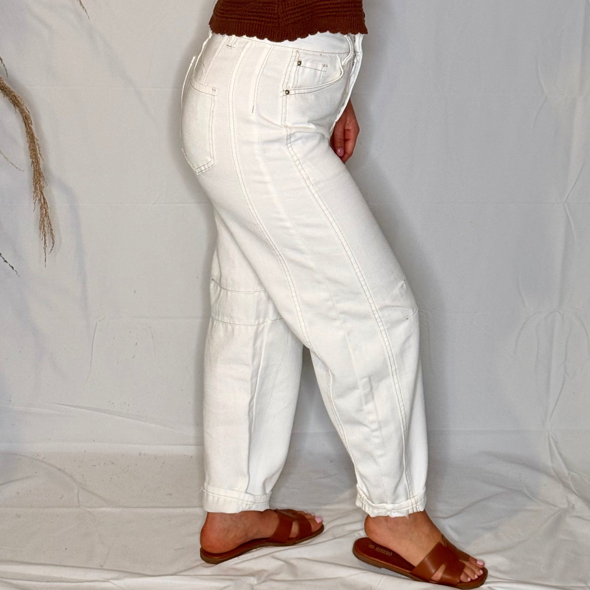 White jeans worn by a person on a plain white background