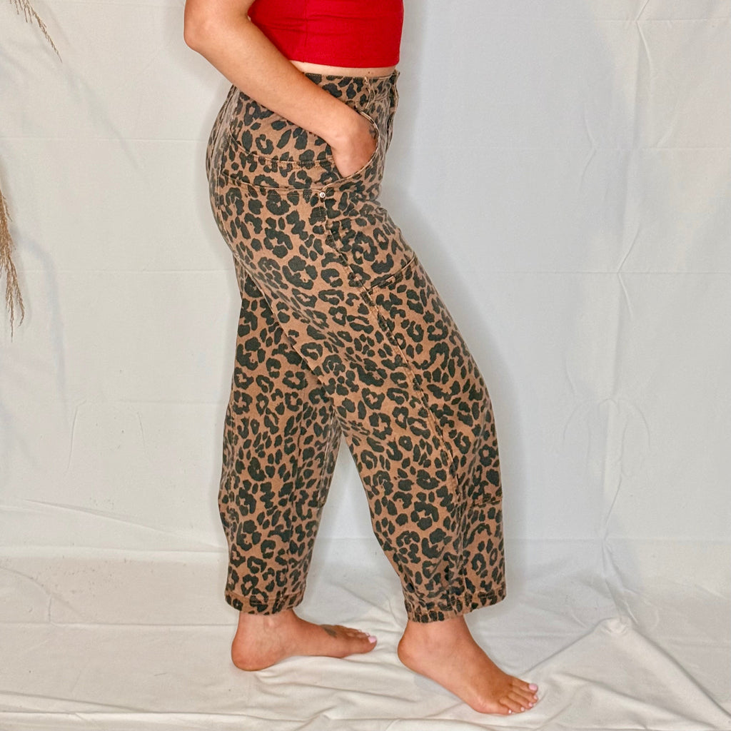 Person wearing red top and leopard print pants on a white background