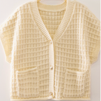 A cream-colored waffle-knit cardigan sweater with short sleeves, a V-neck, and two front patch pockets, hanging on a wooden hanger against a light background.