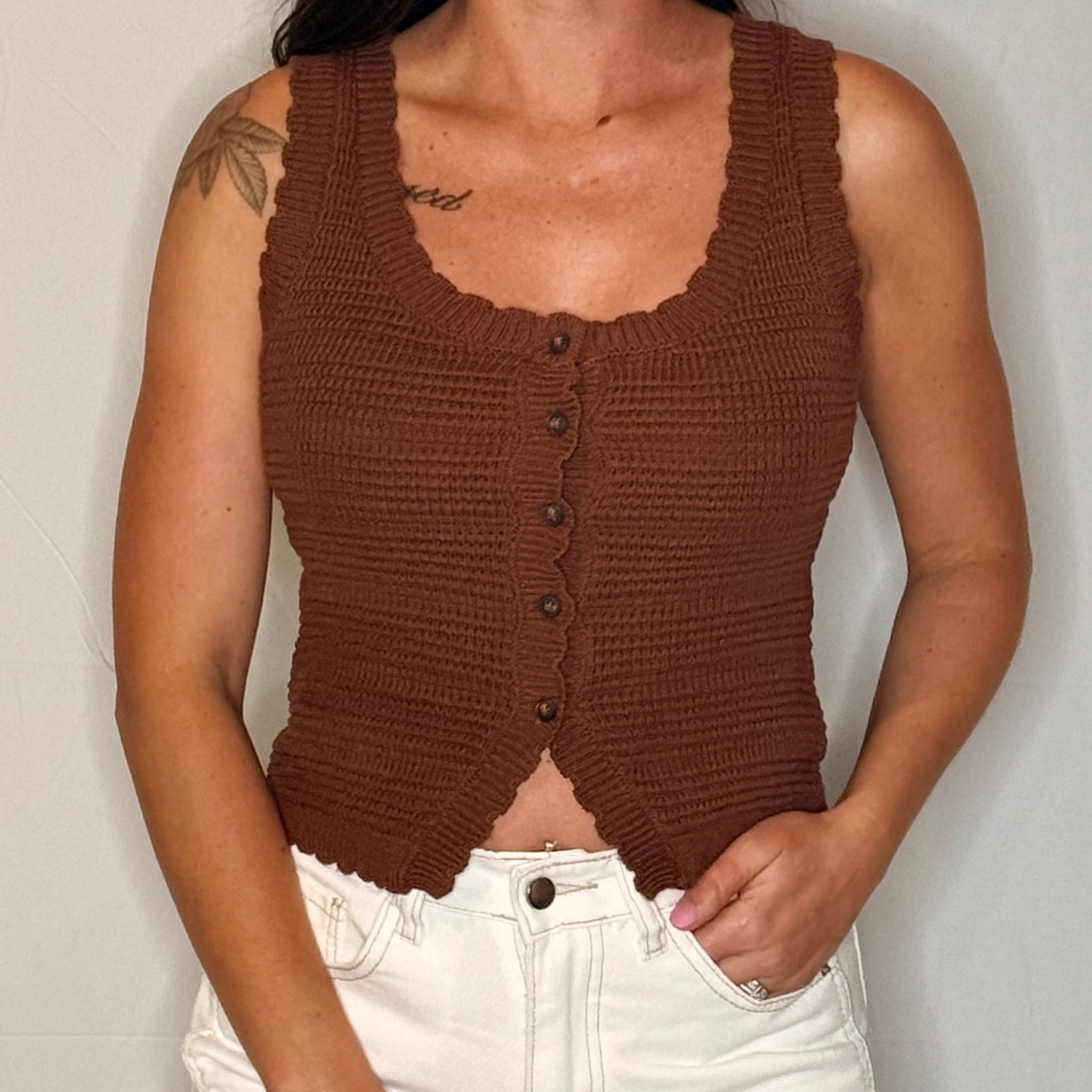 Brown knitted tank top worn by a person on a plain background