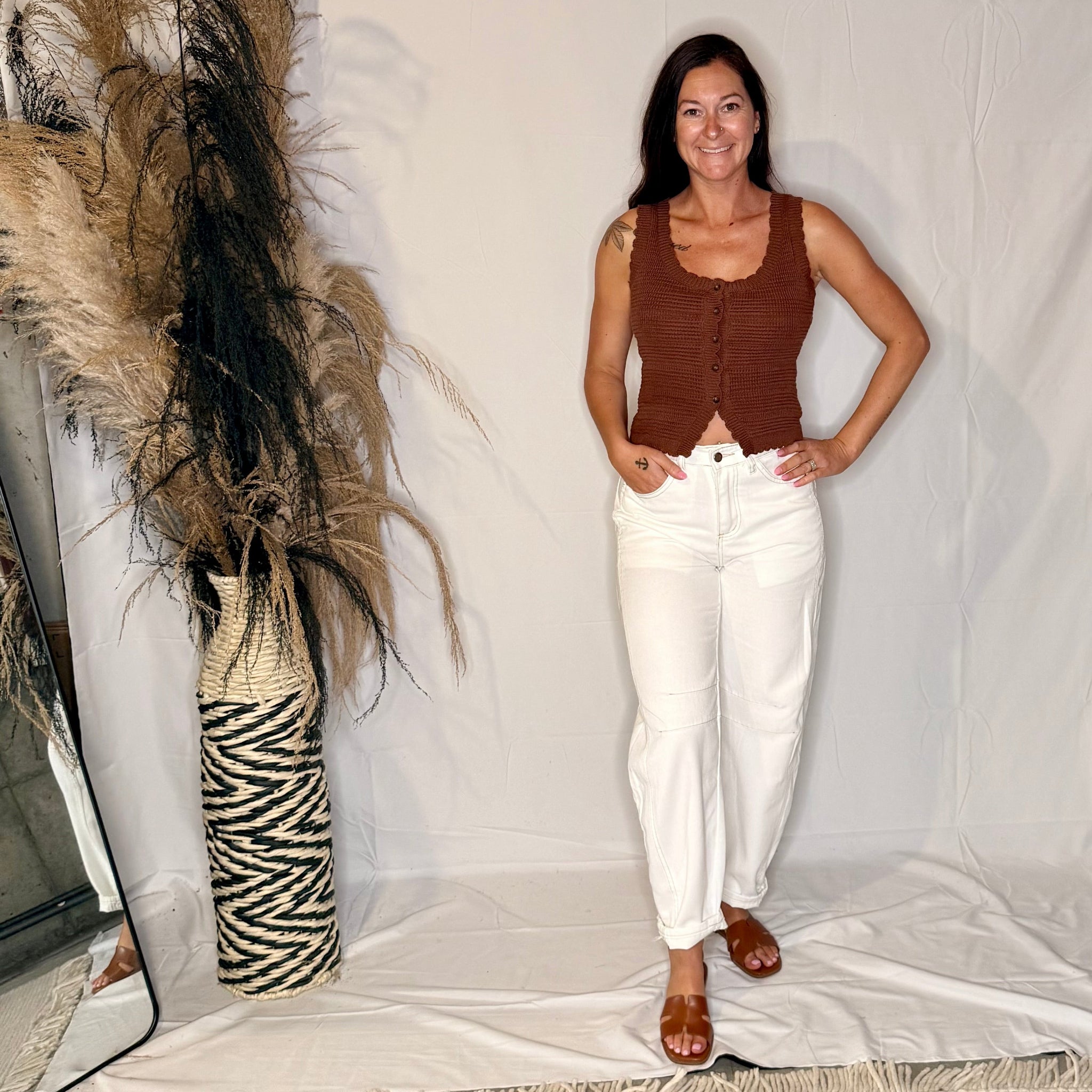 Woman standing in front of a white backdrop with decorative elements