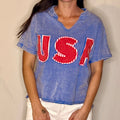 Person wearing a blue t-shirt with 'USA' printed in red and white.