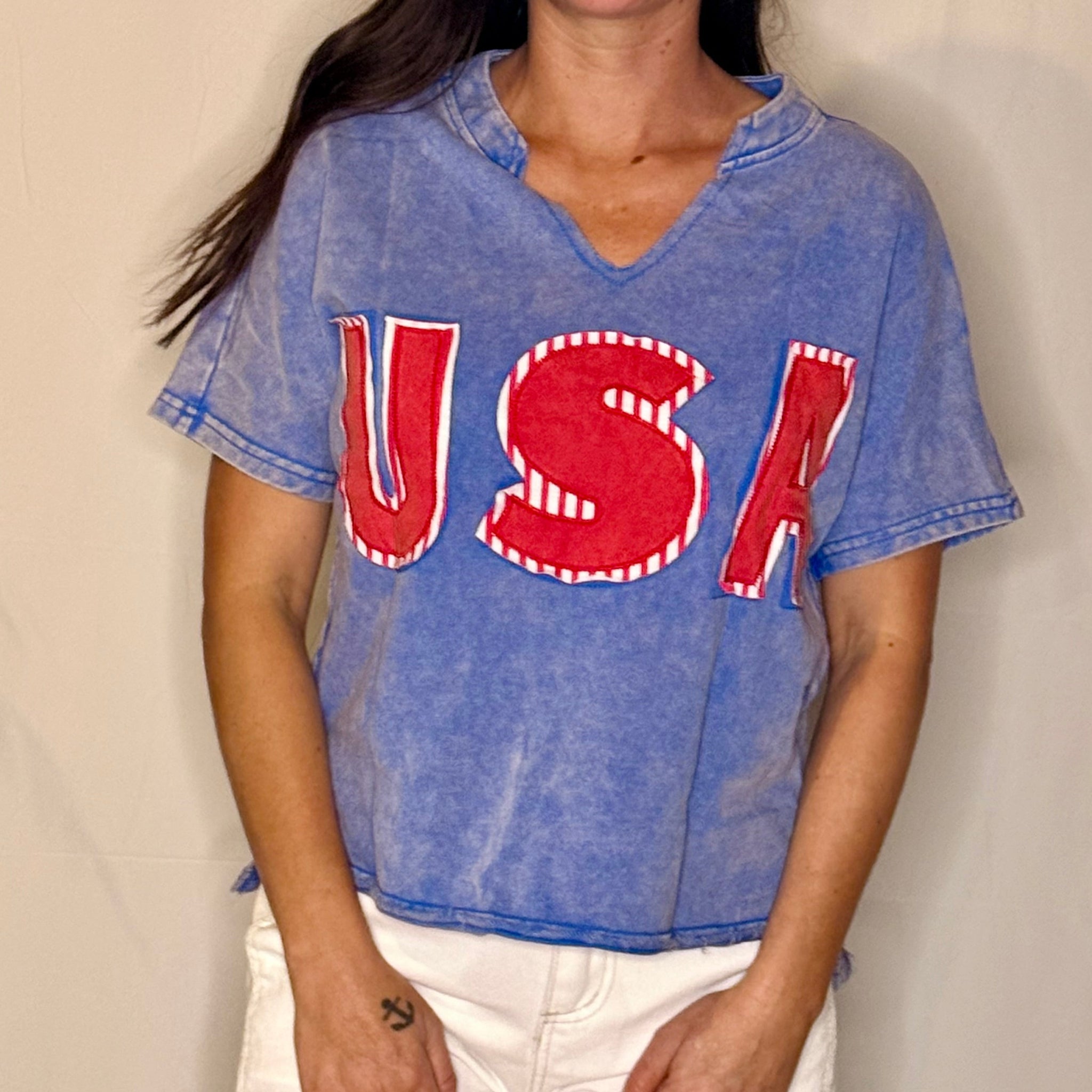 Person wearing a blue t-shirt with 'USA' printed in red and white.